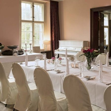 Ein großer Speisesaal mit weißen Tischdecken und Stühlen, der eine elegante Atmosphäre ausstrahlt.