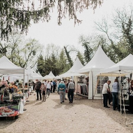 Menschen gehen durch ein Zelt, das mit einer Vielzahl von Blumen geschmückt ist.