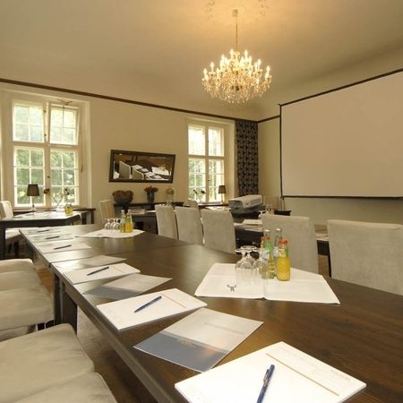 Ein langer Tisch mit Stühlen, die um ihn herum angeordnet sind, ideal für gesellige Zusammenkünfte.