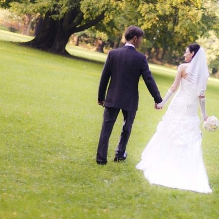 Ein Brautpaar geht Hand in Hand durch ein blühendes Feld, umgeben von natürlicher Schönheit und romantischer Atmosphäre.