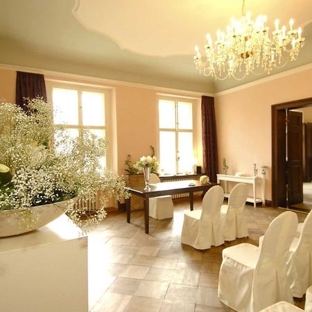 Ein Hochzeitszeremonie-Raum mit weißen Stühlen und Blumenarrangements, festlich und elegant dekoriert.