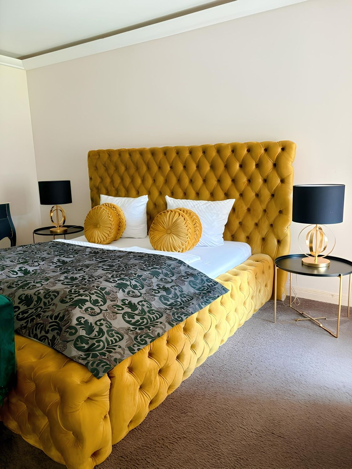 Ein Bett mit einem gelben, gepolsterten Kopfteil, das einen eleganten und modernen Look verleiht.
