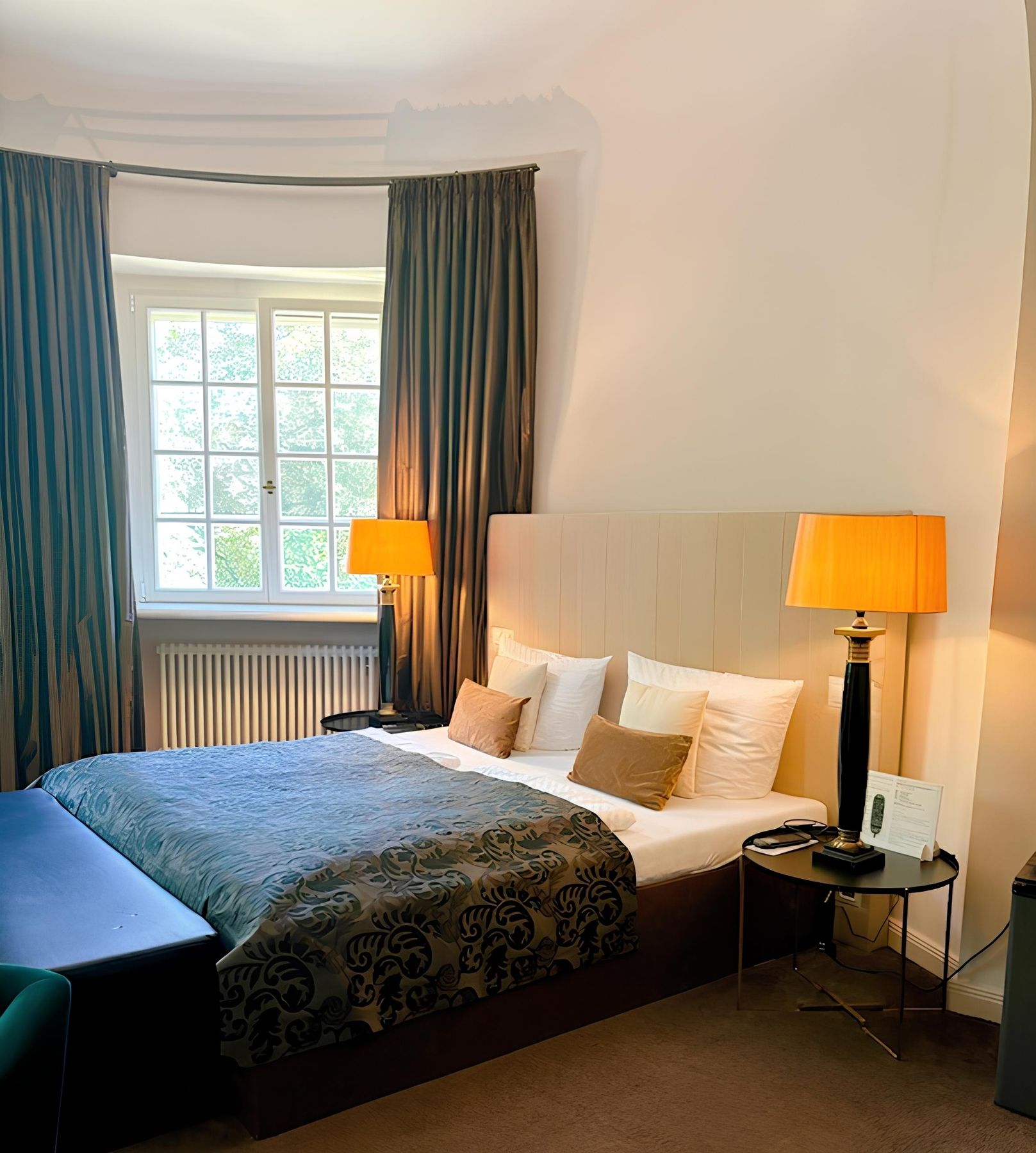 Schlafzimmer mit einem Bett, einem Stuhl und einer Lampe, die eine gemütliche Atmosphäre schaffen.