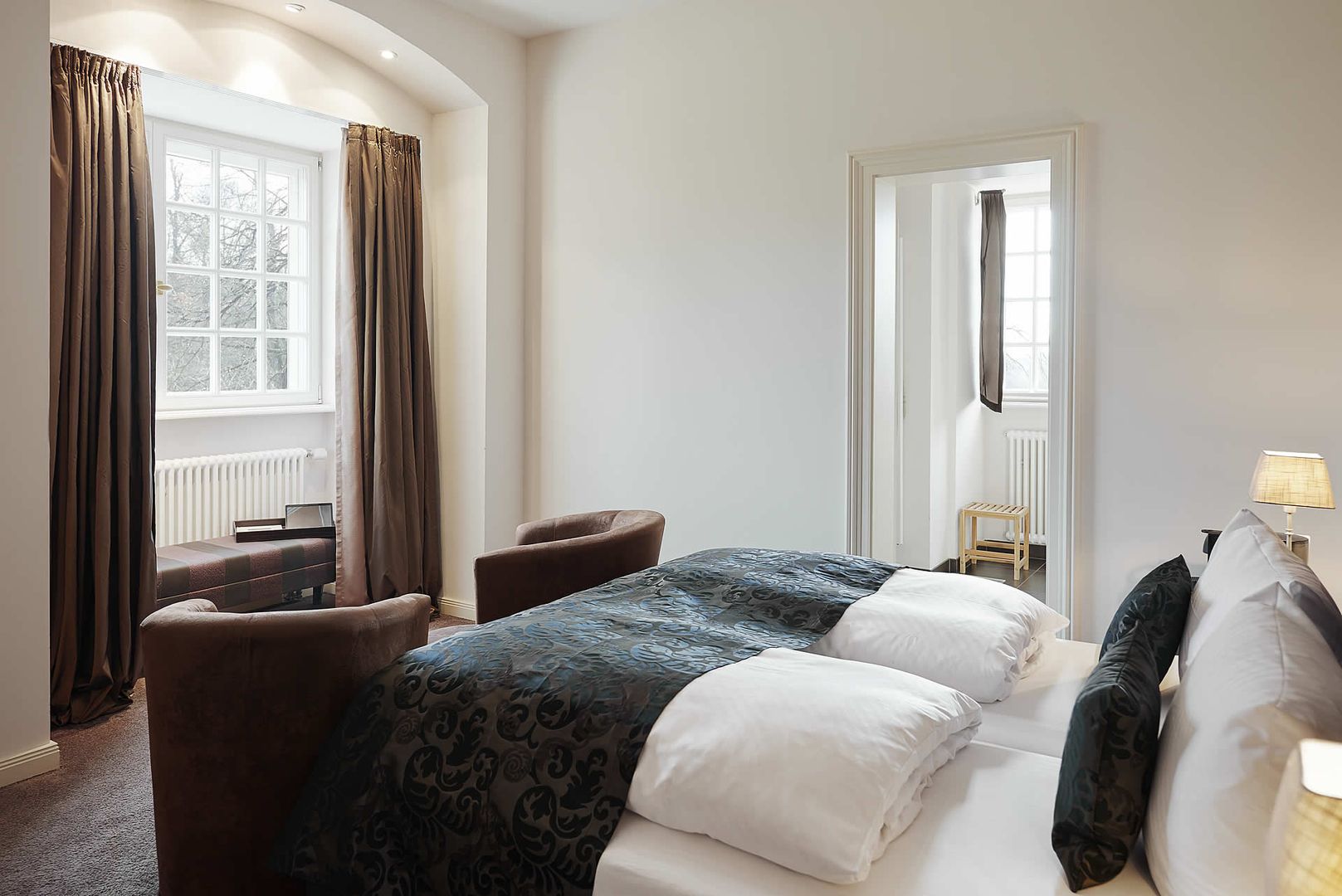 Ein Schlafzimmer mit einem Bett und einem Stuhl, das eine gemütliche und einladende Atmosphäre ausstrahlt.