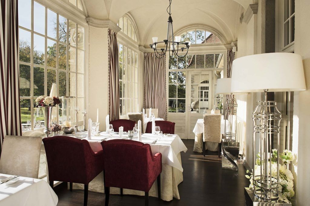 Ein Restaurant mit großen Fenstern und einem einladenden Speisesaal, der eine angenehme Atmosphäre bietet.