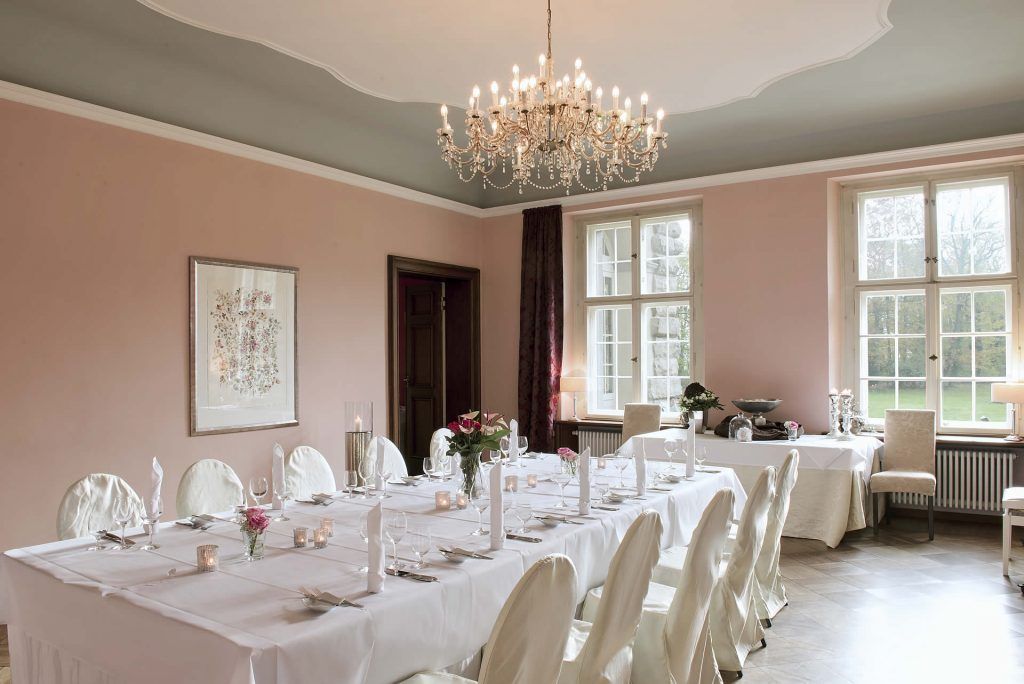 Ein großer Speisesaal mit weißen Tischdecken und Stühlen, der eine elegante Atmosphäre ausstrahlt.