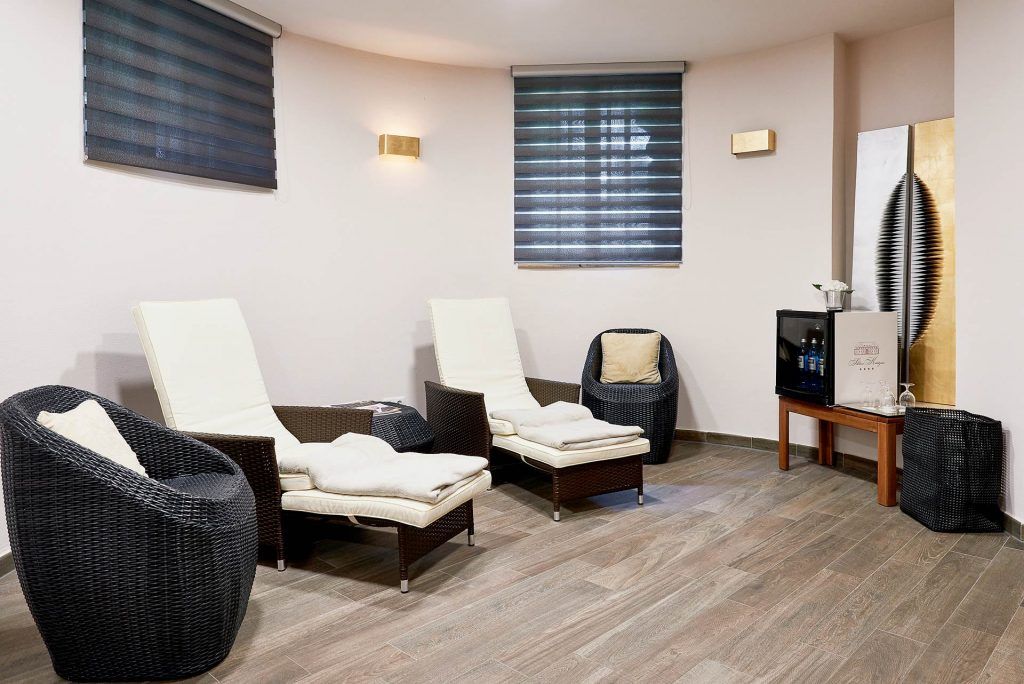 Ein Spa-Raum mit bequemen Stühlen und einem Fernseher, ideal für Entspannung und Erholung.